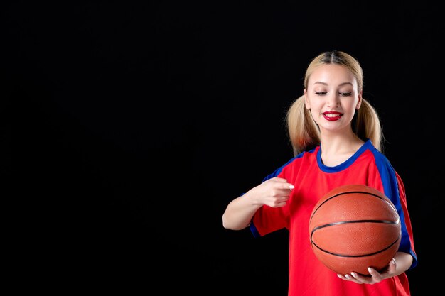 female basketball player with ball on dark isolated background athlete plays game action