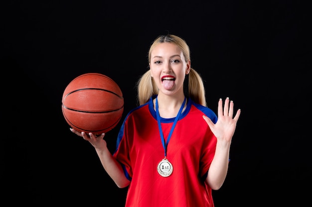 female basketball player with ball and golden medal on black background athlete winner