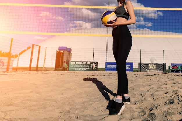 Foto un'atleta di pallavolo da spiaggia con la palla sul campo da pallavolo