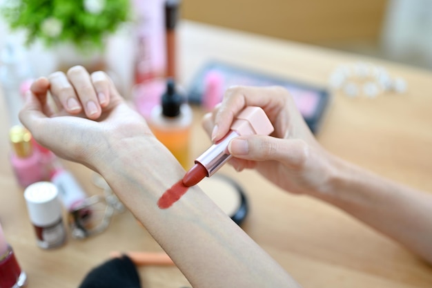 Female beauty blogger testing lipstick on her hand cropped and closeup image