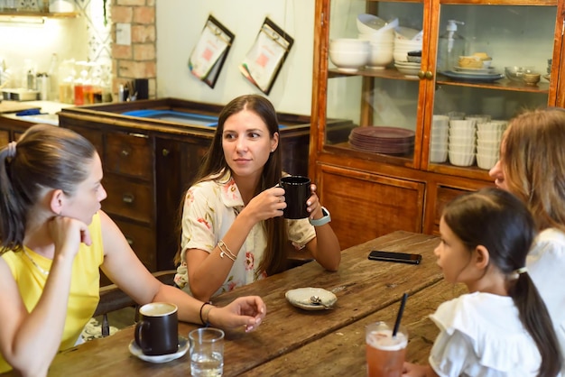 Female best friends talking and eating in a cafe