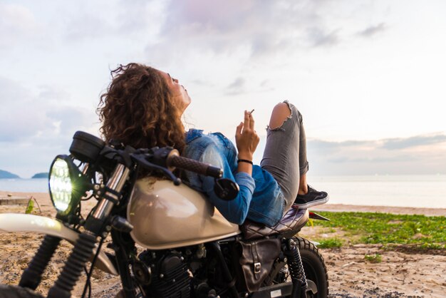 Motociclista femmina alla guida di una moto cafe racer