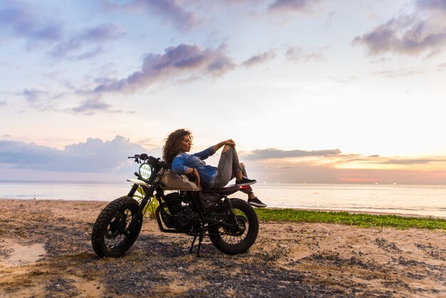 Motociclista femmina alla guida di una moto cafe racer