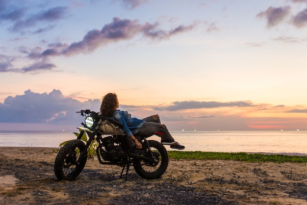 カフェレーサーバイクを運転する女性バイカー