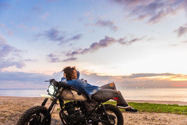 Motociclista femmina alla guida di una moto cafe racer