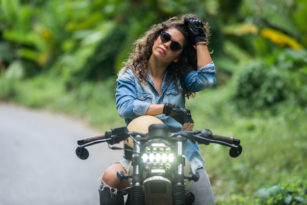 Женский байкер за рулем мотоцикла кафе гонщик