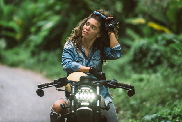 Female biker driving a cafe racer motorbike