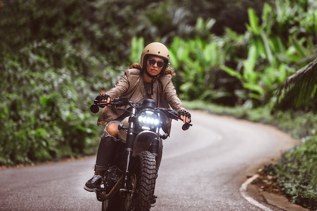 カフェレーサーバイクを運転する女性バイカー