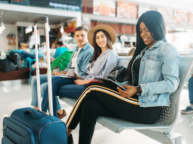 Female black tourist with suitcase in airport