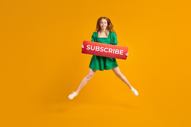 Female blogger asks to subscribe to channel for video vlogs redhead lady in green dress emotionally ...