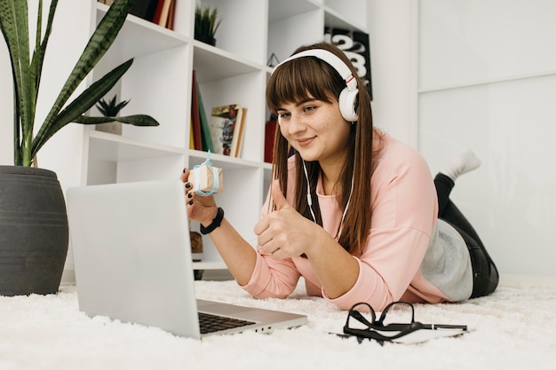 Foto blogger femminile in streaming a casa con laptop e cuffie