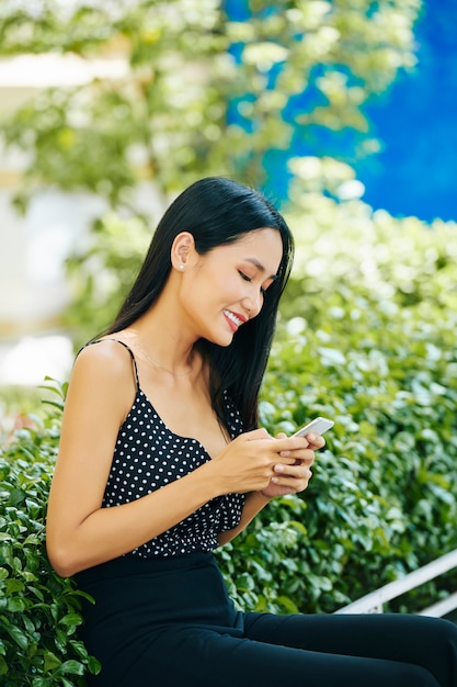 携帯電話を持つ女性のブロガー