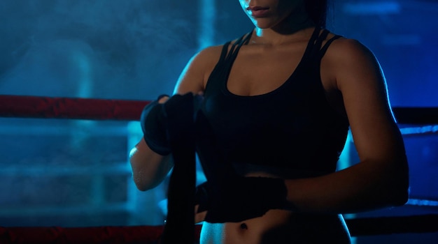 Female boxer binding the bandage on hand