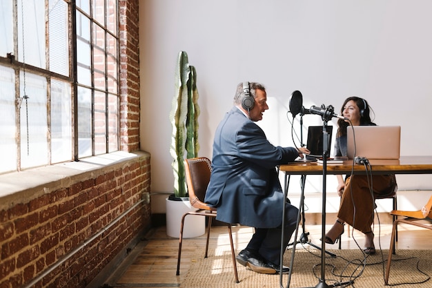 Emittente femminile che intervista il suo ospite in uno studio