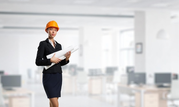 Female builder in the helmet standing