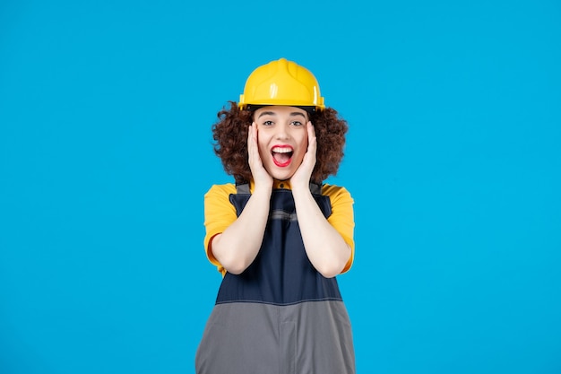 Female builder in uniform on blue