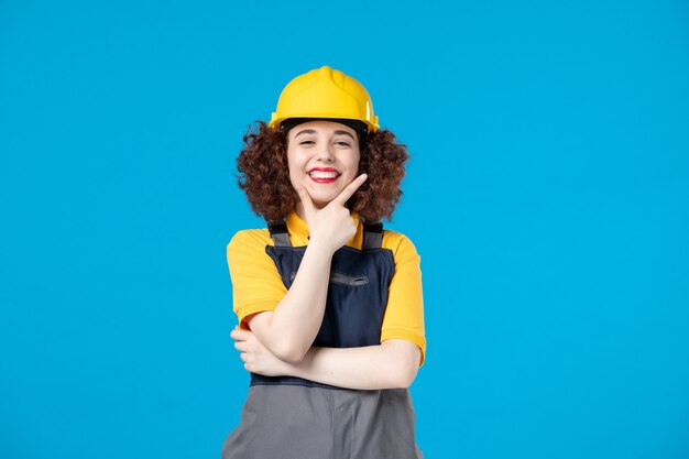 Female builder in uniform on blue