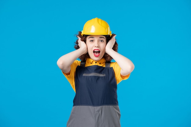 female builder in uniform on blue