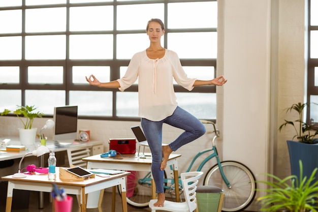 Female business executive performing yoga