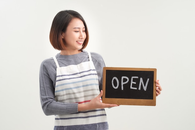 Female business owner holding OPEN sign on white