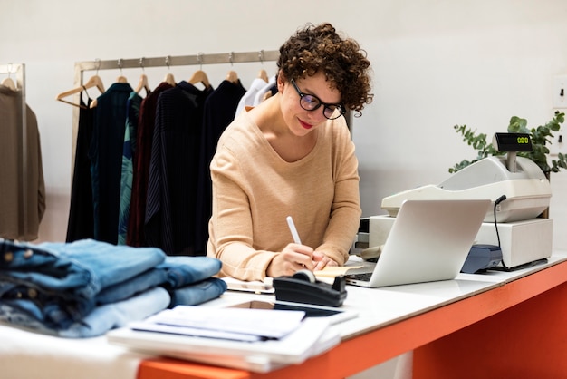 A female business owner is using the laptop