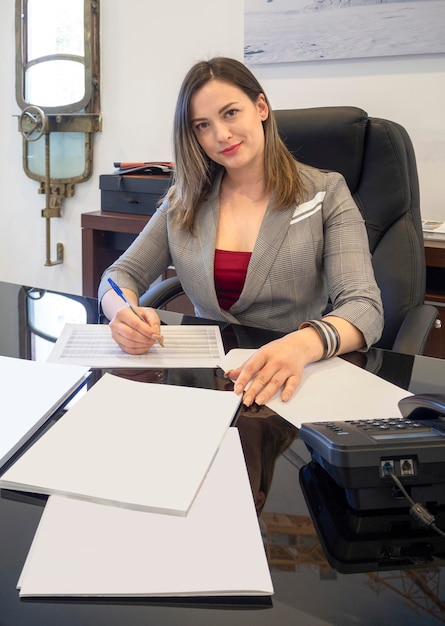 Foto una donna d'affari in ufficio alla scrivania che lavora con i documenti