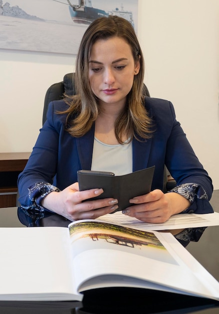 A female businessman in the office at the desk working with documents