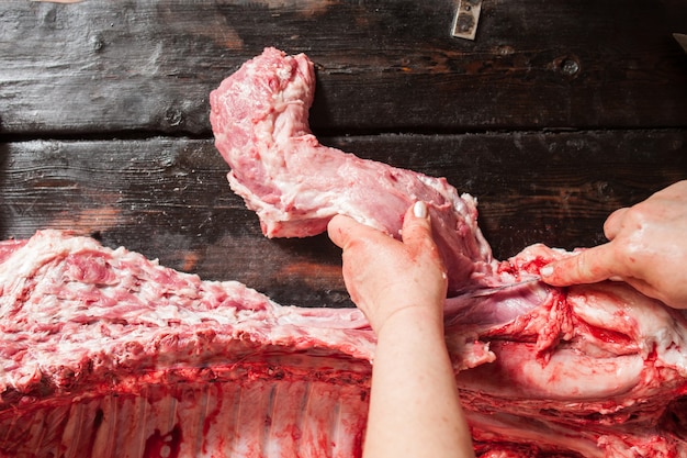 Female butcher carving raw pork chop