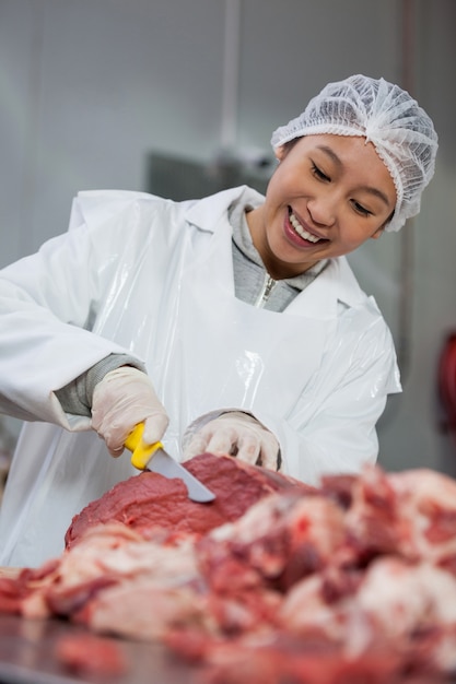 肉工場で肉を切る女性の肉屋