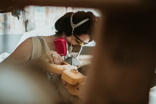 Female carpenter using a compound miter saw