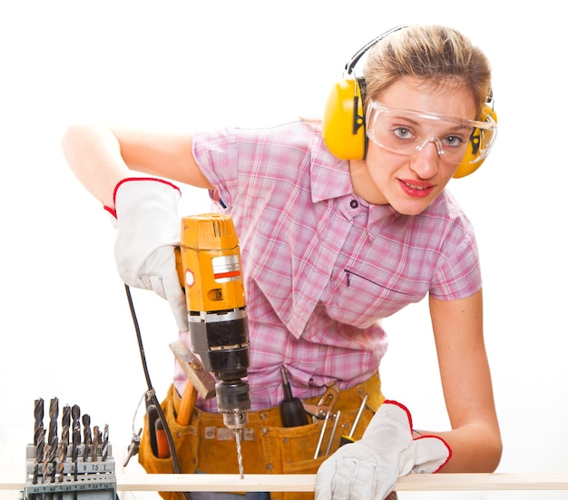 Female carpenter  at work using hand drilling machine