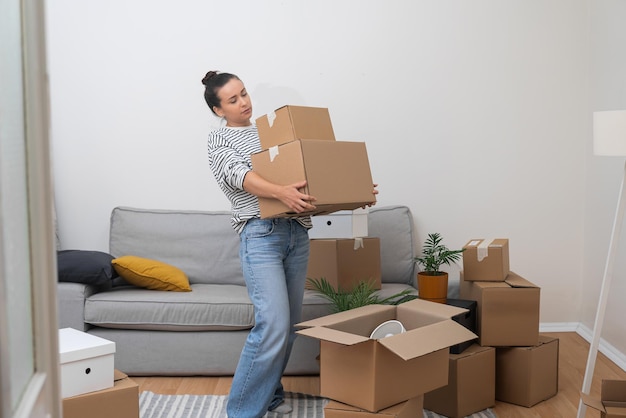 Female carries cardboard boxes with supplies for moving