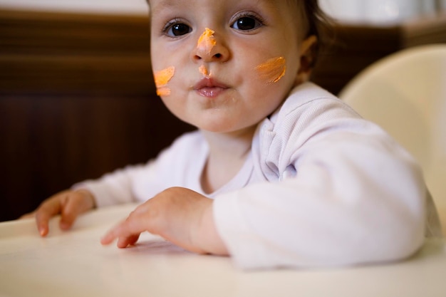 Female caucasian baby with a whipped cream on her face