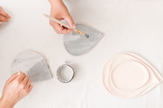 Female ceramist working by hands in pottery studio.