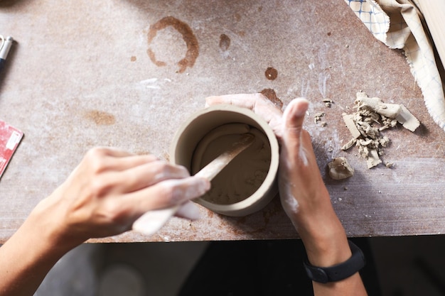 Female ceramist working in pottery studio Ceramist's Hands Dirty Of Clay Process of creating pottery Master ceramist works in her studio