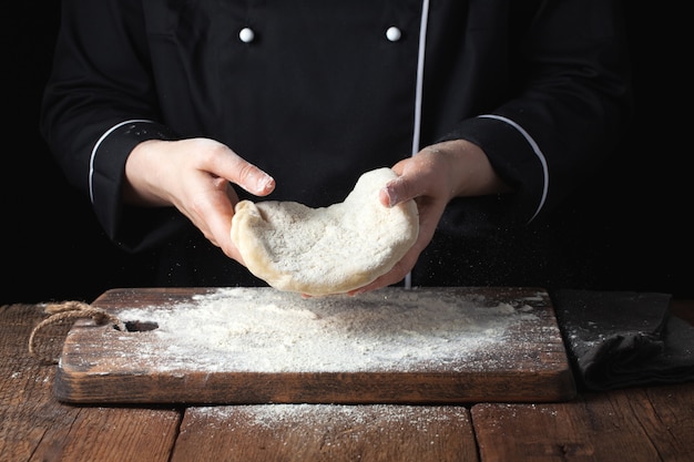 Female chef holding yeast dough.