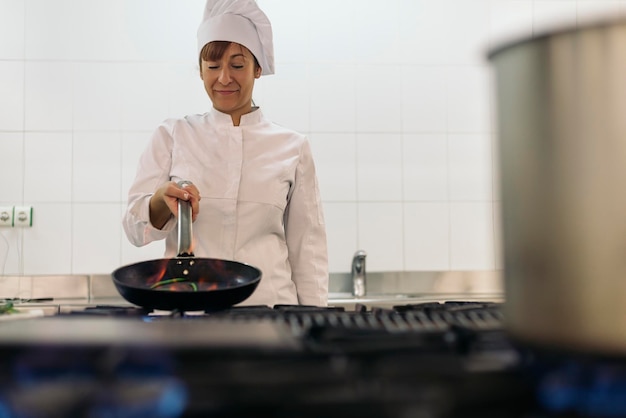 Photo female chef preparing food in commercial kitchen