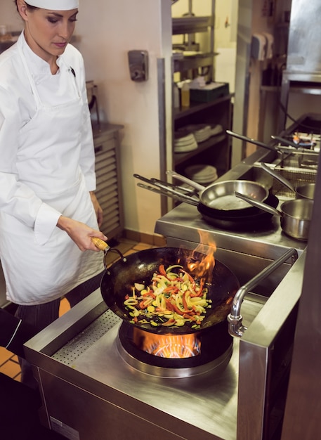 Foto cuoco unico femminile che prepara alimento in cucina