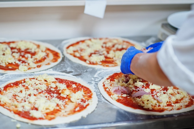 Female chef preparing pizza in restaurant kitchen.