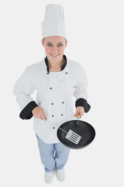 Female chef with spatula and frying pan