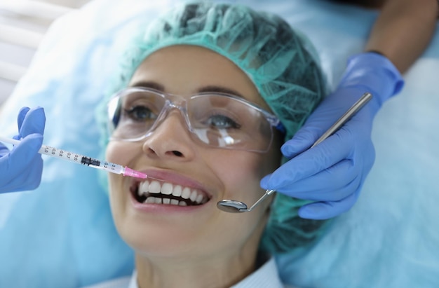 Female client on appointment in stomatology cabinet syringe with painkiller liquid