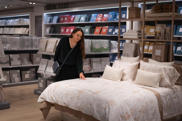 Photo female client choosing bedclothes on bed