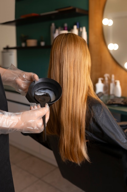 Foto una cliente si sta tingendo i capelli dal parrucchiere.