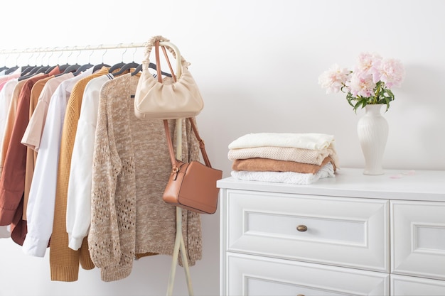 Female clothes on hangers in white room