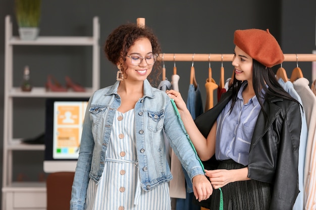 Female clothes stylist with client working in office