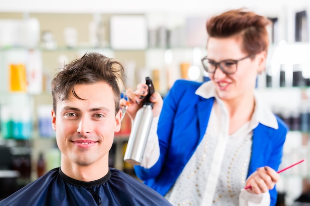 Female coiffeur cutting men hair in hairdresser shop