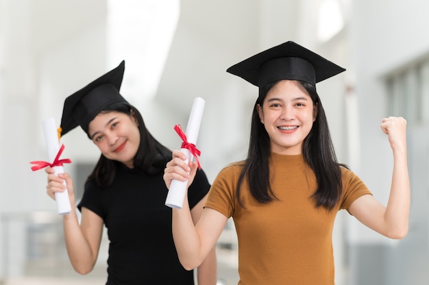 Female college graduates wearing black hats, yellow tassels, smiling and happy on graduation day