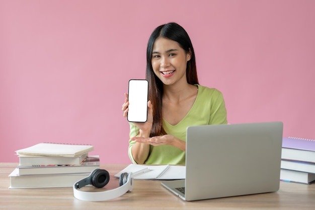 A female college student is showing her smartphone screen to the camera