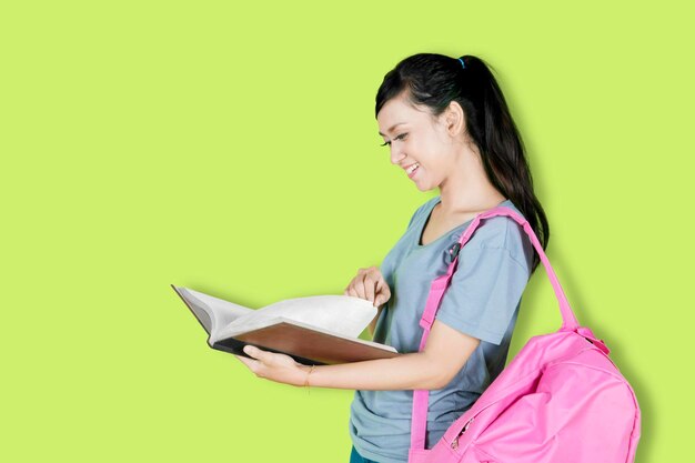 Female college student reading a book in studio