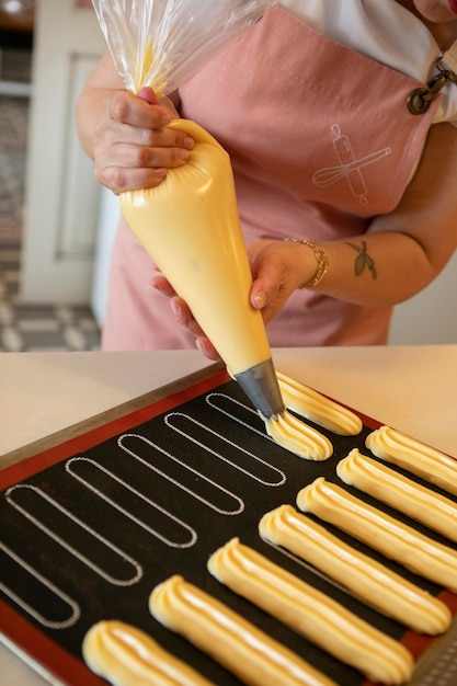 Женщина-кондитер печет тесто в кондитерской